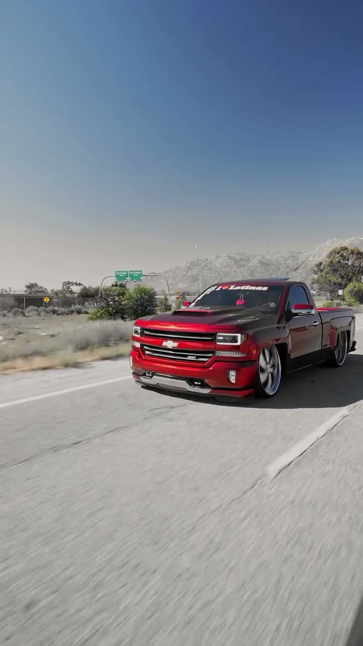 Candy-red dropped Chevy Silverado rolling on the highway