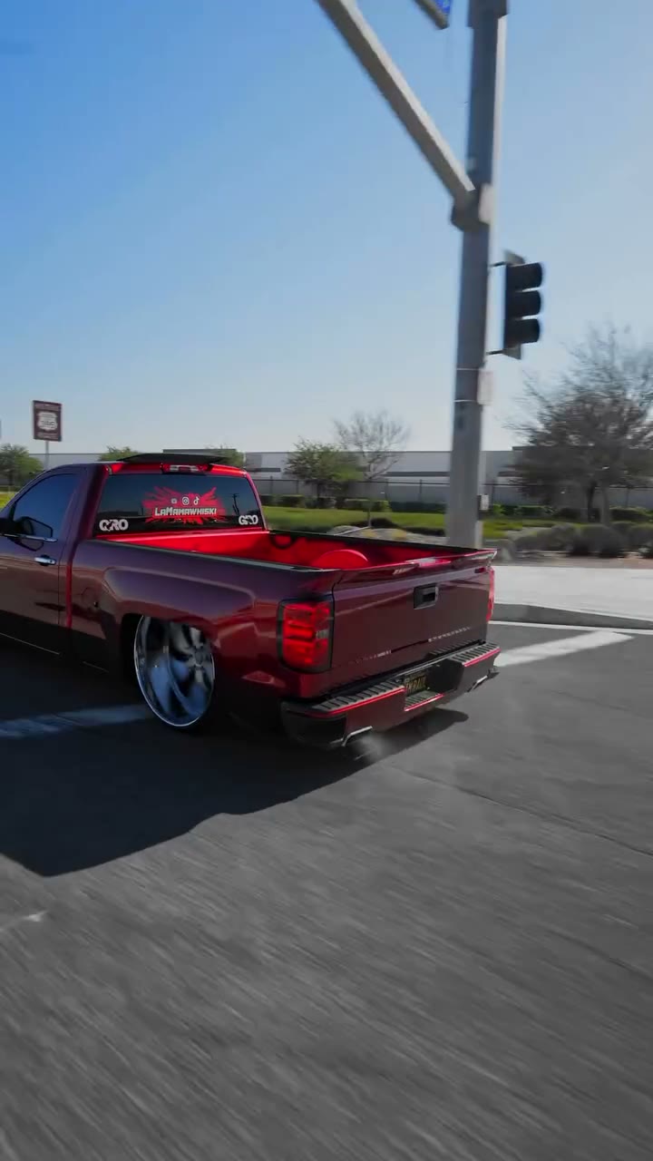 Rear three-quarter of the candy-red Silverado with La Mamawhiski decal